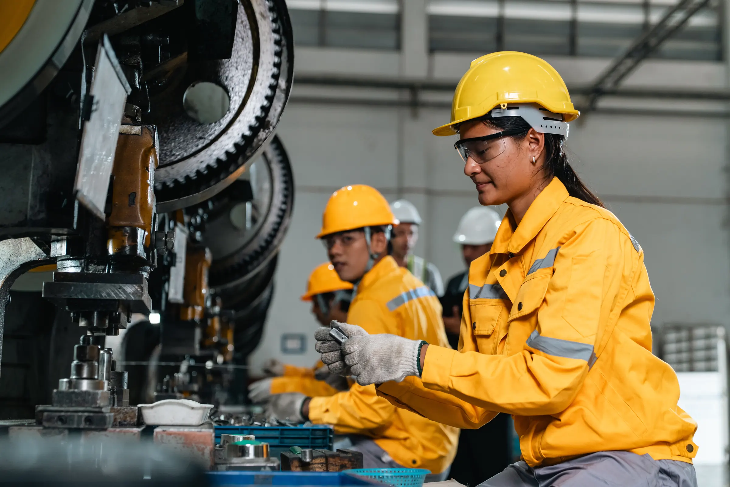 Técnica de segurança orientando trabalhadora de capacete em área industrial
